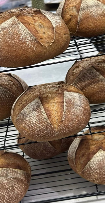 Loaves of bread on a cooling rack with a blurred background